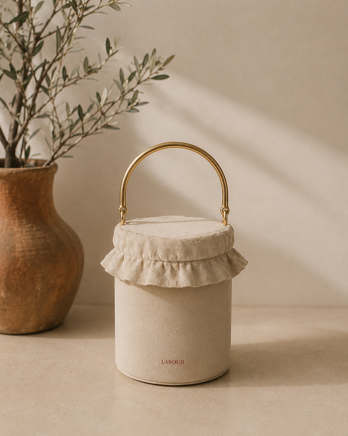 Sac pot LABOUJI ivoire à anse laiton — accessoire signature de la maison de mode parisienne