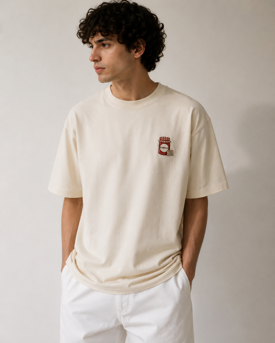 Tee homme LABOUJI écru porté avec pantalon blanc, broderie pot de harissa façon Bonne Maman — capsule unisexe d'été